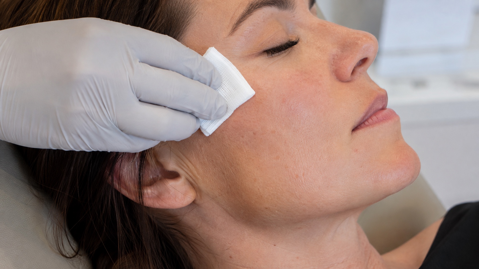 A patient’s cheek being gently prepared with gauze before treatment