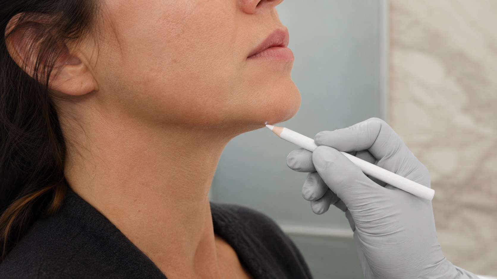 A patient’s jawline and chin being marked carefully before treatment