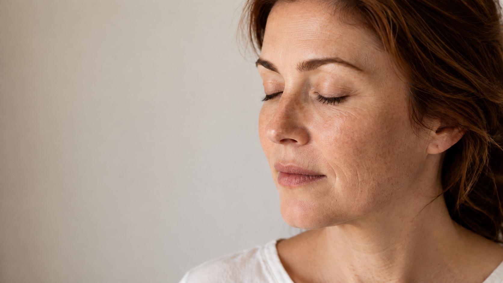 Illustrative portrait of a woman with freckles and uneven skin tone in soft daylight