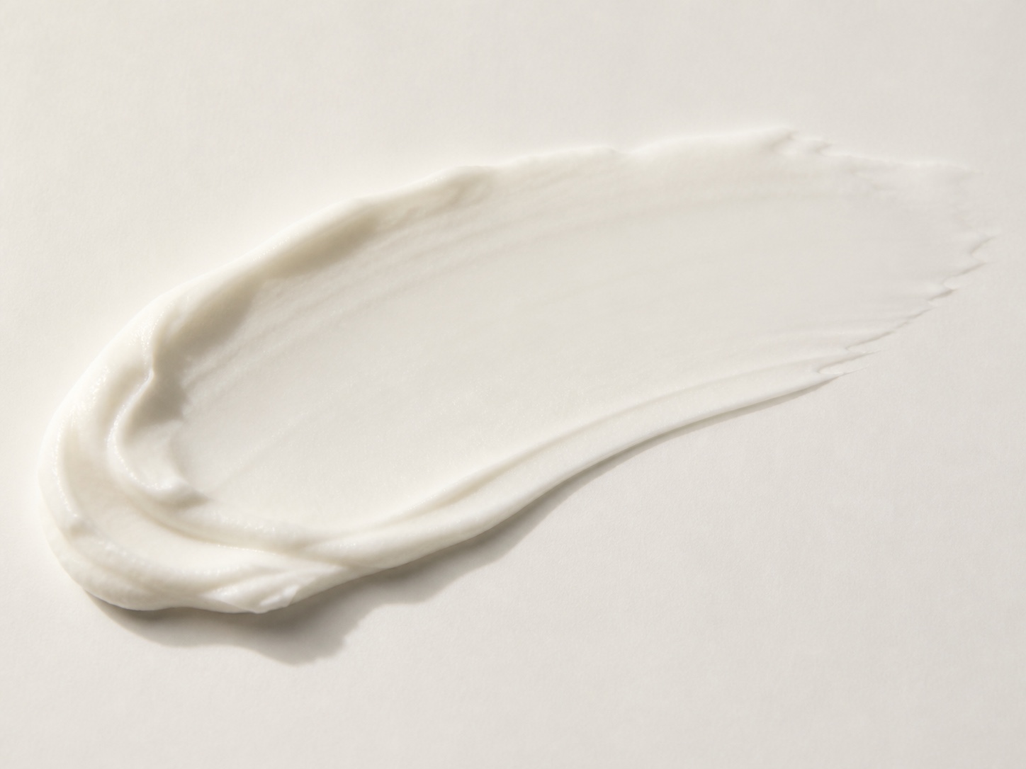 Close-up of a soft white moisturising cream spread across a plain surface